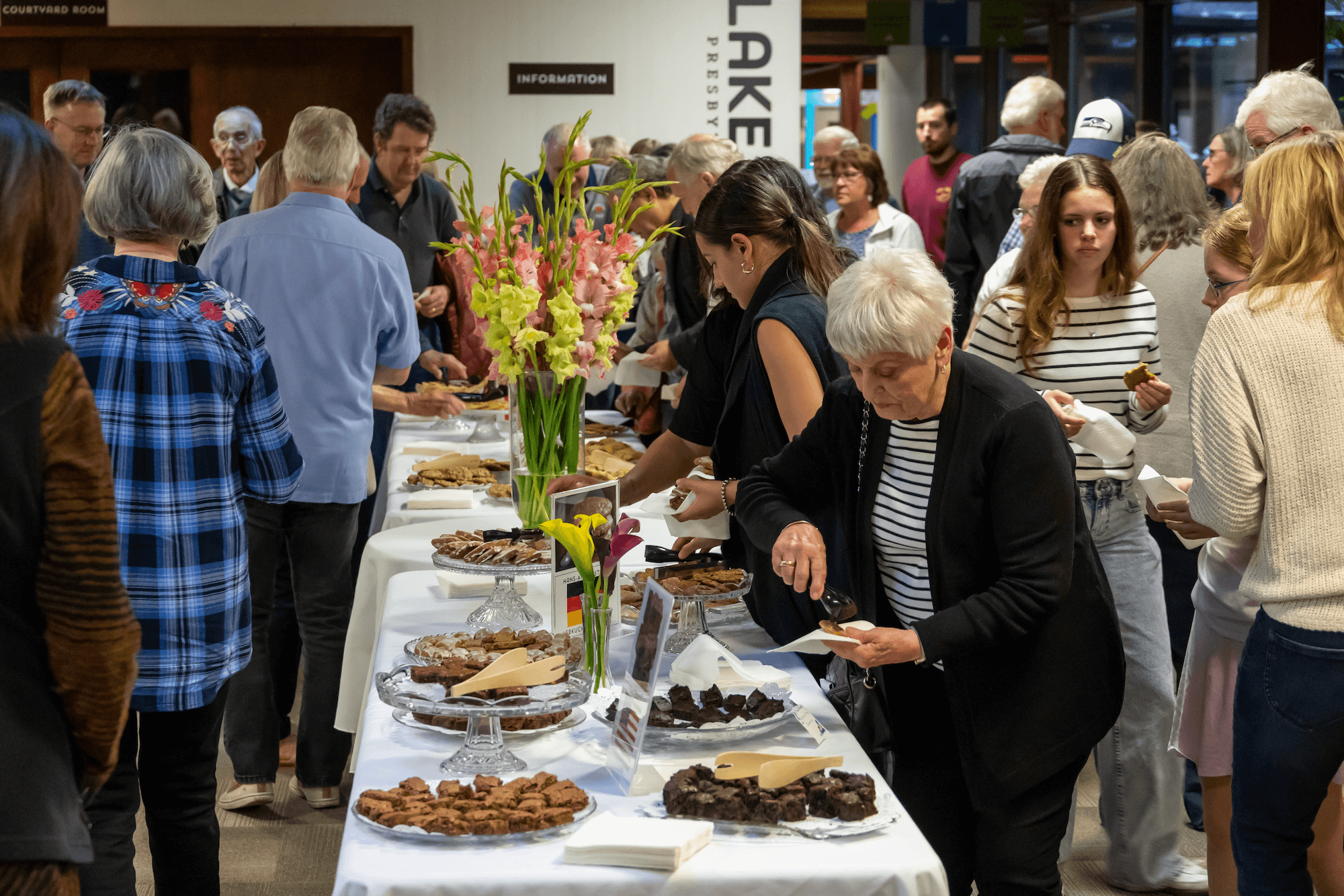 concert-goers enjoying a full table of cookies at a reception